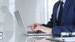 © volha_r - Professional businessman working on laptop computer, typing on keyboard in modern office, managing business tasks. Business people concept