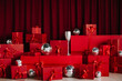 © Balzhan - Stacks of red gift boxes and disco balls in front of a red curtain.