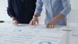 © rogerphoto - Business professionals analyzing financial charts, gesturing over spreadsheets during collaborative meeting in contemporary workspace, discussing data driven insights
