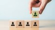 © Shabul - Hand selecting a wooden block with a target icon and person symbol, representing recruitment or selection process