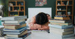 © ChasingMagic25/peopleimages.com - College student, books or girl with sleeping in home for learning break, study fatigue or overworked. Low energy, person and resting at desk for exam revision, academic workload and semester burnout