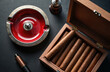 © Viktor - Premium cigars in wooden humidor on dark table with ashtray and lighter. Accessories for smoking are stylish. Luxury lifestyle concept, top view.