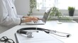 © volha_r - Stethoscope over a medical records are lying on the desk opposite the doctor is typing on a laptop with a in a medical office, suggesting online healthcare or telemedicine services. Medicine concept