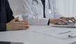 © rogerphoto - Doctor and a patient in clinic. The female physician is using laptop computer for filling up medication history record form, close up. Medicine and science