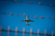 © MartinM - Hamburg, Deutschland, 7.9.2025: Flugzeug beim Start hinter Absperrung mit Stacheldraht am Flughafen Hamburg