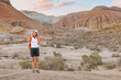 © EdNurg - Happy hiker taking a selfie with smartphone while hiking in the desert mountains