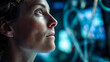 © ABF_MATEO - A focused woman looks up, bathed in blue light, surrounded by technology. Determination and curiosity are evident in her expression.