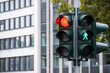 © Yahor - Traffic light displaying red and green signals for vehicles and pedestrians, positioned on a street corner, with modern buildings in the background, illustrating urban traffic management