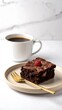 © Bumbu - Chocolate brownie with raspberry garnish, coffee cup, gold fork, on white marble surface