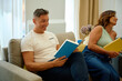 © Cristian Blázquez - Couple relaxing on sofa reading books together