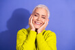 © deagreez - Smiling mature woman with short white hair in a bright yellow sweater enjoying happiness against a purple background for lifestyle wellness