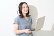 © Yamatatsu - 白背景でパソコンを持つ日本人女性