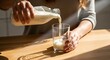 © Octopus16 - Woman Pouring Milk Into Glass on Wooden Table in Bright Kitchen
