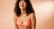 © Graphic Ornaments - Woman laughing with curly dark hair wearing coral lace bra