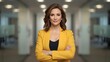 © Imagine  - Professional indoor portrait of a confident businesswoman standing with folded arms in a modern corporate hallway, expressing leadership, expertise, determination, and strong executive presence in sof