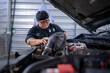 © Apichat - Mechanic woman repairing car engine in auto shop