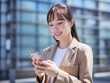 © maaagram - スマホを操作する笑顔の女性　Generative AI