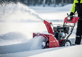 Red snow blower clearing snow from a field on a winter day, showcasing efficient snow removal and winter maintenance in a snowy landscape