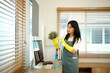 © Stella 16 - Housekeeper cleaning white flower pot with yellow gloves