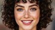 © vadosloginov - Smiling young woman with curly hair and freckles showcases natural beauty in a close-up portrait