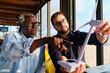 © Westend61 - Engineers having discussion and examining wind turbine model in restaurant