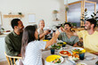 © Westend61 - Cheerful family raising toast at dining table in kitchen