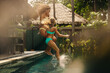 © Jacob Lund - Family enjoying vacation at a resort villa, jumping into the pool, summer fun
