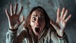 © ds17 - Young Caucasian woman with brown hair and wide eyes screaming with hands raised in fear or shock indoors.