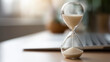 © Denis Yevtekhov - Hourglass on desk with last minute inscription defocused office, faceless time pressure, travel visualization detail, blurred workspace background, vacation sale concept, tourism i