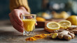© ink drop - Hand holding turmeric and ginger immunity shot — healthy detox drink