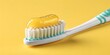 © RAFI - Bright yellow toothpaste glistens on white toothbrush bristles ready for clean teeth