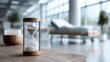 © Di Studio - sand timer placed on a table inside an empty modern hospital room, representing time, waiting, and healthcare concepts.