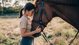 Serene side-profile shot of a young female rider in casual equestrian attire, hugging her brown horse on a sunlit meadow, showing trust and the close human-animal relationship