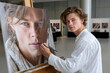 © YouraPechkin - Young artist paints a detailed portrait at a contemporary art event in a modern gallery setting