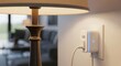 © PixelProCreative - A smart plug is plugged into a wall outlet next to a lamp in a living room with a blurred background