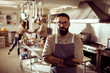 © Davor - Adult male chef with confident expression in restaurant kitchen