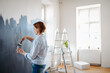 © Halfpoint - Beautiful woman painting walls of her new apartment by herself.