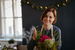 © Halfpoint - Smiling female florist working in her small flower shop.