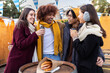 © Xavier Lorenzo - Multiracial young group of friends having fun together at christmas market on winter holidays