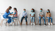 © Prostock-studio - Nurse provides antiviral vaccine injections to a diverse group of children indoors. Kids are seated and waiting their turn in a clinic. The setting has a neutral gray wall backdrop.