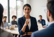 © ZHMPRO - Confident indian businesswoman leading a meeting, pointing finger at someone, giving instructions to colleagues in a modern office space