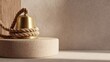 © Line - Gold bell with coiled rope on beige stone pedestal