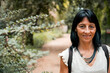 © Cavan Images - Smiling woman in forest, close-up portrait on nature path