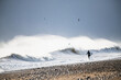 © Cavan Images - Man going surfing winter waves during snow storm