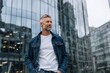 © Tondo - Mature man in denim jacket standing confidently in city