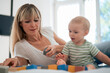 © Westend61 - Mother and son spending leisure time playing with toy blocks on bed at home