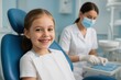 © Z - young girl sitting in a modern dental clinic, smiling confidently in a blue dental chair while a masked dentist prepares instruments in the background