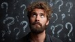 © backup_studio - Man looking up with many question marks around him on a dark background. Doubt, confusion, and contemplation concept. Finding a solution.
