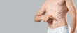 © Pixel-Shot - Young man with markings on his abdomen against grey background, closeup. Plastic surgery concept
