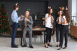 © Pixel-Shot - Young colleagues drinking champagne at New Year party in office